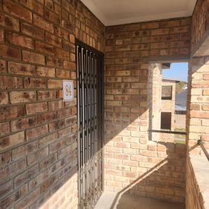 a brick wall with a gate on it at Two Bedroom townhouse THE PINES ALBERTSDAL in Alberton