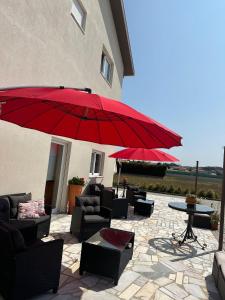 a patio with a red umbrella and chairs and a table at Guest House MJ in Póvoa de Varzim