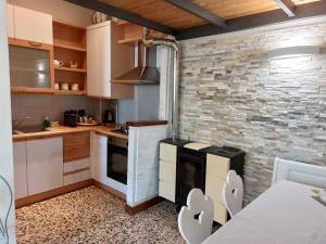 una cocina con armarios blancos y una pared de ladrillo en Elena Casa Turistica, en Padua
