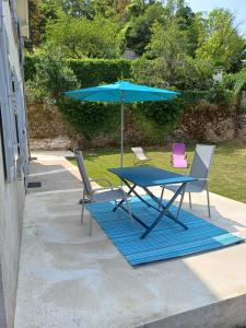 una mesa con sombrilla azul y 2 sillas en Proche centre ville, en Mende