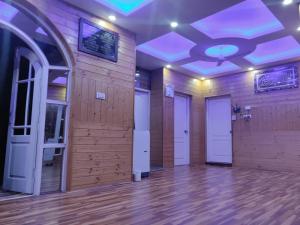 ein leeres Zimmer mit Holzwänden und weißen Türen in der Unterkunft AuraB&B Homestay in Srinagar