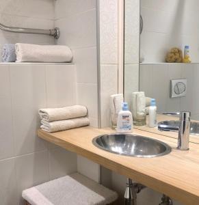 a bathroom with a sink and a mirror and towels at Olga apartment in Rīga