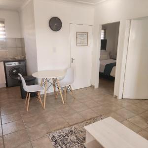 a living room with a table and chairs and a bed at Two Bedroom townhouse THE PINES ALBERTSDAL in Alberton