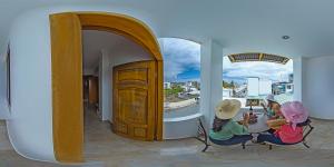 a painting of two women sitting at a table at Hostal España in Puerto Ayora