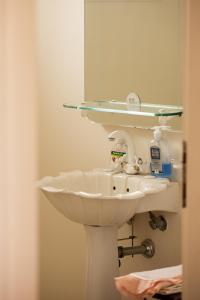 La salle de bains est pourvue d'un lavabo blanc et d'un miroir. dans l'établissement Zeusplace PoolVilla Natura, à Kateríni