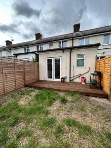 a wooden deck in front of a house at Bali Bliss Garden Flat with Parking in Enfield