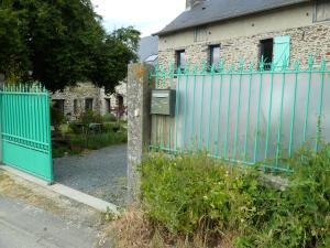 uma cerca azul em frente a uma casa em L' ALBIZIA em Saint-Martin-de-Sallen