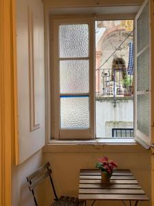 una ventana con un banco y una maceta en Saudade Guest House, en Lisboa