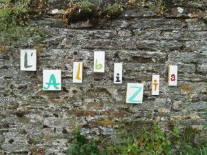 uma parede de pedra com sinais alfabéticos. em L' ALBIZIA em Saint-Martin-de-Sallen