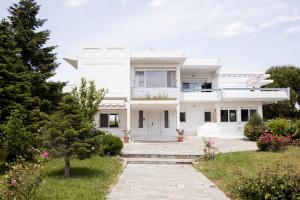 a white house with a garden in front of it at Zeusplace PoolVilla Natura in Katerini