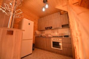 a kitchen with wooden cabinets and a white refrigerator at Wonder Inn 