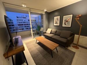 a living room with a couch and a table at Oceana Suites Capital in Santiago