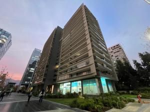 a tall building with people standing in front of it at Oceana Suites Capital in Santiago