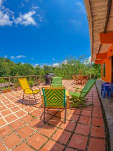 a patio with colorful chairs and tables on it at Finca San Cayetano - Minca in Arimaca
