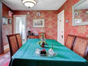 a dining room with a table with a green table cloth at Adorable 2-bedroom unit with jacuzzi beside falls in Niagara Falls