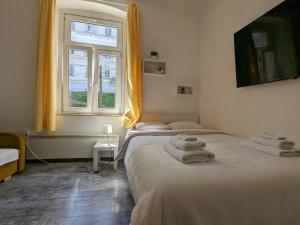 a bedroom with two beds and a window at Tilted Painting Near The Stone Gate in Zagreb