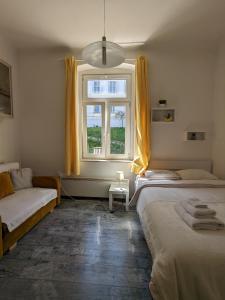 a bedroom with two beds and a window at Tilted Painting Near The Stone Gate in Zagreb