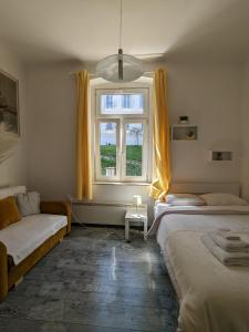 a bedroom with two beds and a window at Tilted Painting Near The Stone Gate in Zagreb