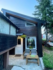 a tiny house with a door and two chairs and a table at Guest House Durmitor Paradise in Žabljak
