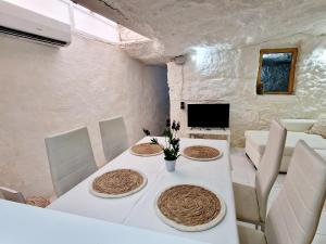 uma sala de jantar com uma mesa branca e cadeiras em Casa Cueva a 15 minutos del centro de Valencia em Paterna