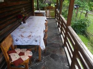 a table and chairs on the porch of a cabin at Delia in Ocna Şugatag