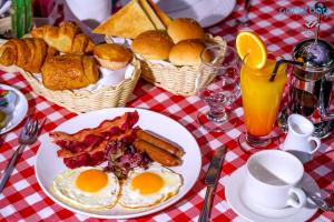 a table with eggs and bacon and baskets of bread at C Hotel in Manama