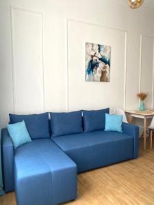 ein blaues Sofa im Wohnzimmer mit einem Tisch in der Unterkunft Квартира на Огієнка 15 in Lwiw