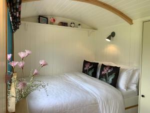 a bedroom with a bed with pink flowers on it at St. Kew Shepherd Huts in Wadebridge