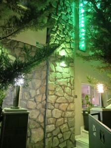a building with a stone wall with a green light at Green House in Nea Peramos