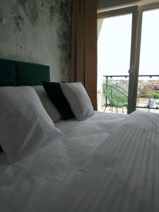 sypialnia z dużym białym łóżkiem i balkonem w obiekcie Apartamenty Mistral w Jastarni
