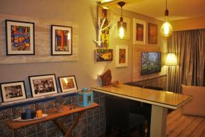 um quarto com uma mesa e algumas fotos na parede em Quintinha D`Arga em Caminha