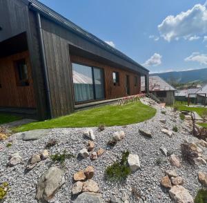 a house with a gravel yard next to a building at CHALET COBURG in Telgárt