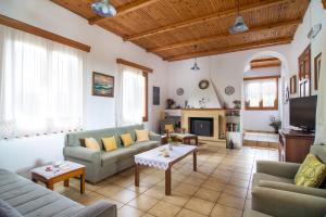 a living room with two couches and a tv at Plakias Villas in Lefkogeia