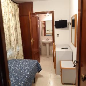 a small bathroom with a bed and a sink at Lizana 2 in Huesca