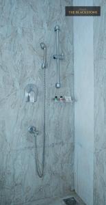W łazience z kamienną ścianą znajduje się prysznic. w obiekcie Hotel The Black Stone w mieście Bengaluru