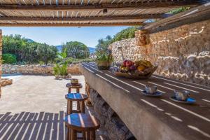 a stone wall with a basket of fruit on a table at BLUE VILLA in Kampos Paros