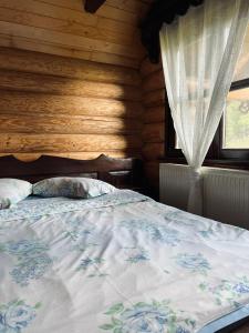 a bedroom with a bed with a wooden wall at Casa de vacanta Aida in Zărneşti