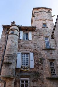 Vabres-lʼAbbaye的住宿－La Maison des Echevins，一座旧砖砌建筑,设有白色门窗