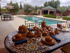 une table avec des tasses et des assiettes en dessus dans l'établissement Dar Chenguiti, à Taroudant