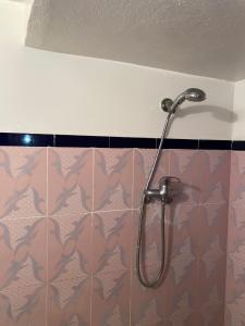 a shower in a bathroom with a camo tile wall at Panorama guest house in Sidi Ifni
