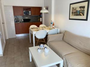 a living room with a couch and a table at Sunny apartment with pool in Tossa de Mar