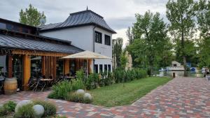 a white house with a patio and a brick yard at Sissy20 Apartman in Budapest