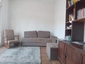 a living room with a couch and a chair at Hostel Leonardo 10 Estrelas in Vitória