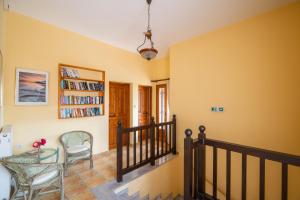 a hallway with a staircase with chairs and a book shelf at Seralis Pelion in Afissos