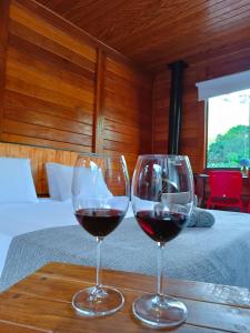 two glasses of red wine sitting on a table at Refúgio Allamanda Flats in Visconde De Maua