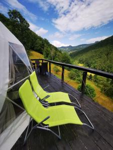 a pair of green chairs sitting on a deck at Apuseni Glamping Retreat in Bucium +48 photos