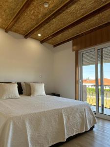 1 dormitorio con cama blanca y ventana grande en Guest House MJ, en Póvoa de Varzim