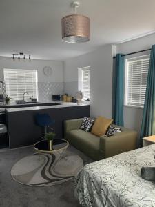 a living room with a couch and a kitchen at Entire Brand New Serviced Apartment in Moseley in Birmingham