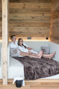 un hombre y una mujer sentados en una cama en Löckerwirt, en Sankt Margarethen im Lungau