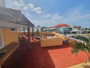 a balcony with a table and chairs and an umbrella at Suites Los Arcos in Isla Mujeres